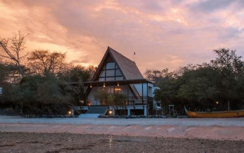 a small house with a gambrel roof on a beach at Plataran Menjangan Resort and Spa - CHSE Certified in Banyuwedang