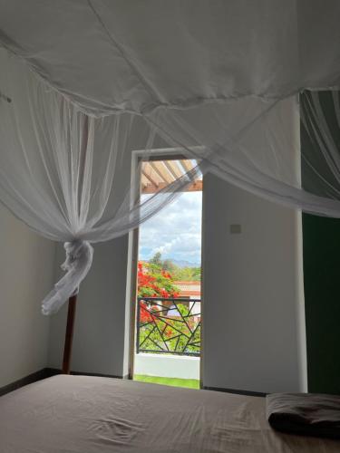 a bedroom with a bed with a canopy and a window at Meilleur appartement meublé de Diego Suarez in Diego Suarez
