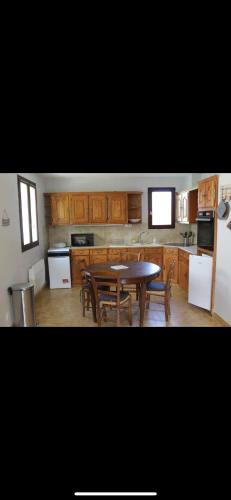 une cuisine avec une table et des chaises dans l'établissement Maison de vacances, à Saint-Trojan-les-Bains