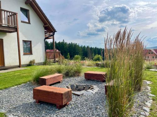 a garden with three benches and a fire pit at Apartmány MAX in Vaclavov u Bruntalu