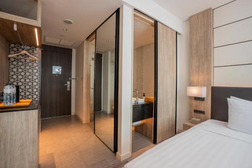 a bedroom with a bed and a bathroom at Solaria Nishitetsu Hotel Bangkok in Bangkok
