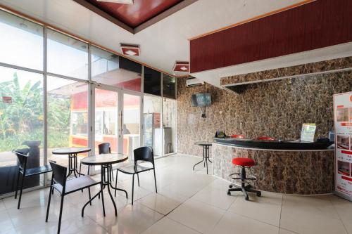 a kitchen with tables and chairs and a counter at My home2 Mall Ciputra Cibubur Redpartner in Kranggan-wetan Satu