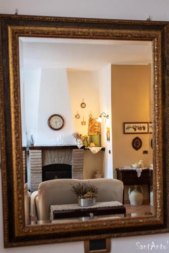 a mirror reflecting a living room with a fireplace at SantAntò nel cuore di Trivigno 120 mt in Trivigno