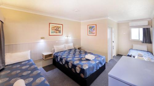 a hotel room with two beds and a couch at Mackay Rose Motel in Mackay