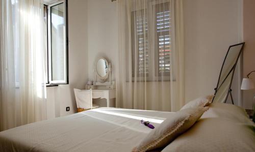 Habitación blanca con cama y ventana en Apartment Bacvice, en Split