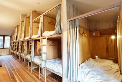 a room with a row of bunk beds at WGJ Hostel Kyoto in Nishi-kujō-Toriiguchichō