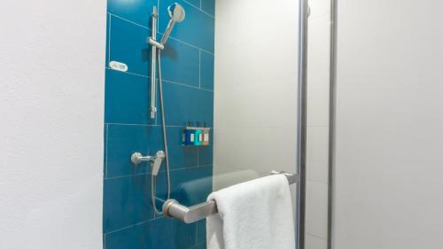 a bathroom with a shower with blue tiles at Holiday Inn Express Shanghai Pudong Airport by IHG in Shanghai