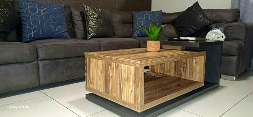 a wooden coffee table in front of a couch at NJ MERENSKY 1 Windhoek in Windhoek