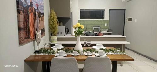 a dining room table with chairs and a kitchen at NJ MERENSKY 1 Windhoek in Windhoek