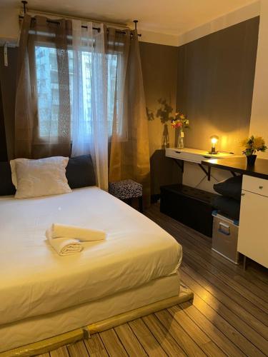 une chambre avec un grand lit blanc avec une fenêtre dans l'établissement Comfortable Studio in Clichy, à Clichy