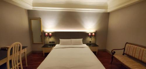 a bedroom with a bed and a couch in it at 麗隆商旅LilongHotel in Kaohsiung