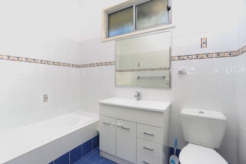 a bathroom with a toilet and a sink and a mirror at Lovely Pet Friendly Beach House in Hawks Nest