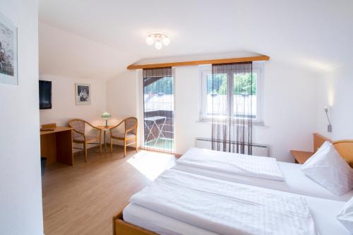 a bedroom with two beds and a desk and a table at Ferienwohnungen Gabriel in Keutschach am See