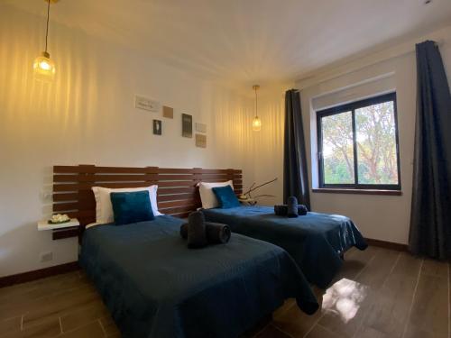- une chambre avec 2 lits avec des draps bleus et une fenêtre dans l'établissement Villa vue mer à 300m du centre ville de Porto-Vecchio, à Porto-Vecchio
