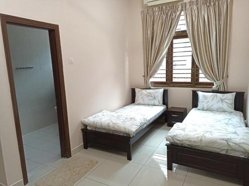 a room with two beds and a shower and a window at Eden Nomad Living in Batu Ferringhi