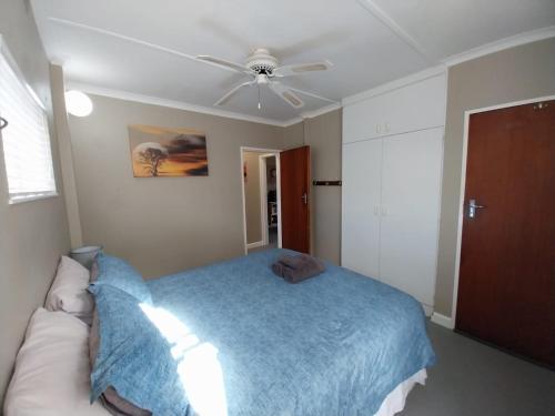 a bedroom with a bed and a ceiling fan at Bushmansriver Tree-House in Bushmans River Village