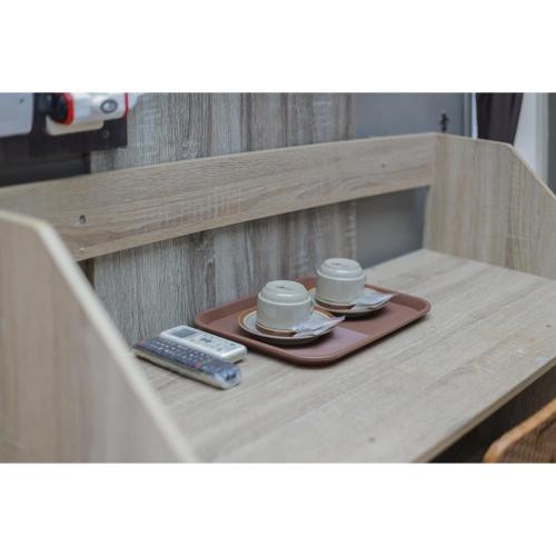 a tray with two coffee cups and a remote control at Reddoorz Syariah at House Of Melati Kepanjen in Malang