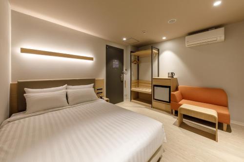 a bedroom with a bed and a chair and a television at Nishitetsu Hotel Croom Bangkok Silom in Bangkok