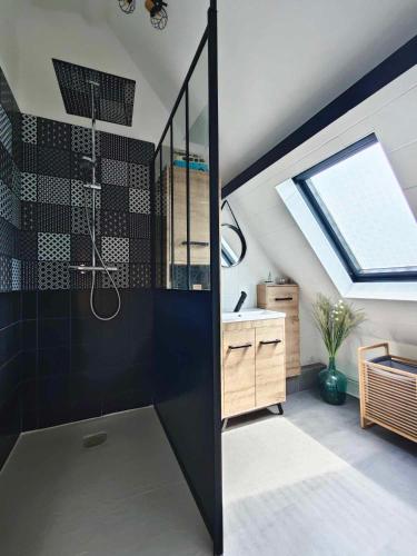 La salle de bains est pourvue d'une douche, d'un lavabo et d'une lucarne. dans l'établissement O coeur des Monts et Merveilles, à Wormhout