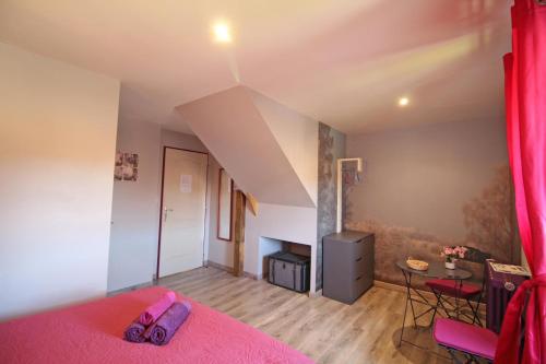 a bedroom with a pink bed and a table at L'etable des saveurs in Cieux