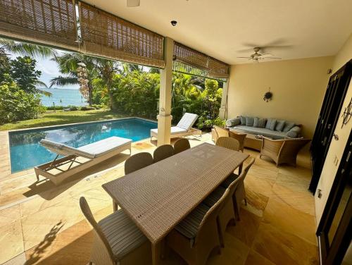 a dining room with a table and a swimming pool at Eden Island Luxury Accommodation in Eden Island