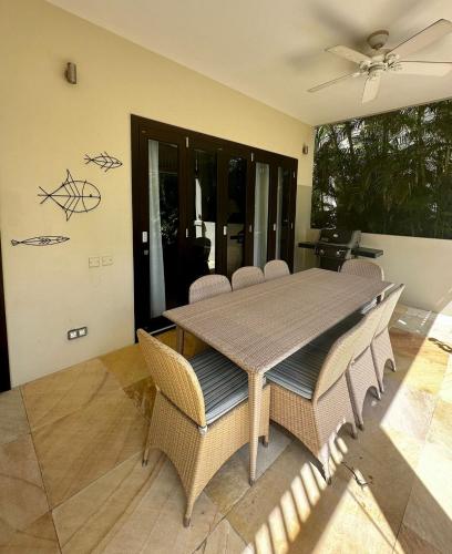 a dining room table with chairs and a ceiling fan at Eden Island Luxury Accommodation in Eden Island