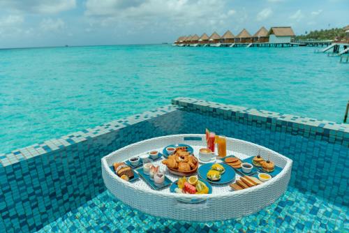 a tray of food on a table in the water at Mercure Maldives Kooddoo - Adults - Only Escape - 50 percent off Transfers in Gaafu Alifu Atoll