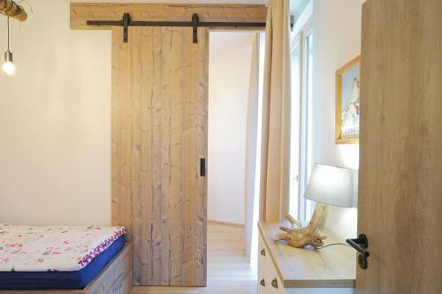a bedroom with a wooden door and a bed and a lamp at Ski Apartment Hillside in Dolný Kubín