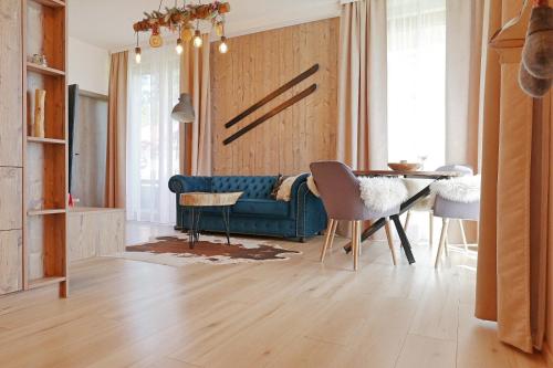 a living room with a blue couch and a table at Ski Apartment Hillside in Dolný Kubín