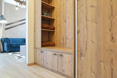 a wooden cupboard in a room with a blue couch at Ski Apartment Hillside in Dolný Kubín