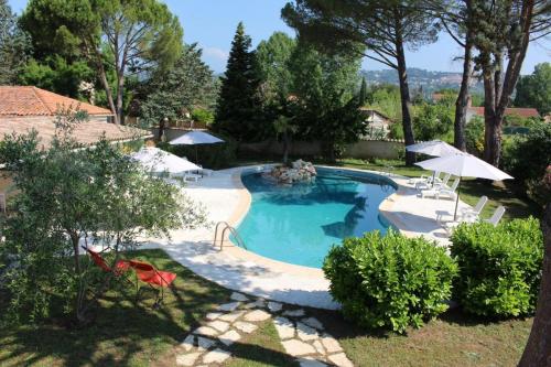 - une piscine dans une cour avec des chaises et des parasols dans l'établissement La cigale rouge a callian, à Callian
