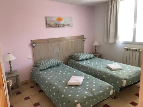 - 2 lits dans une petite chambre avec des draps verts dans l'établissement La cigale rouge a callian, à Callian