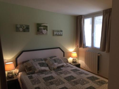 une chambre avec un lit avec deux lampes et une fenêtre dans l'établissement La cigale verte a callian, à Callian