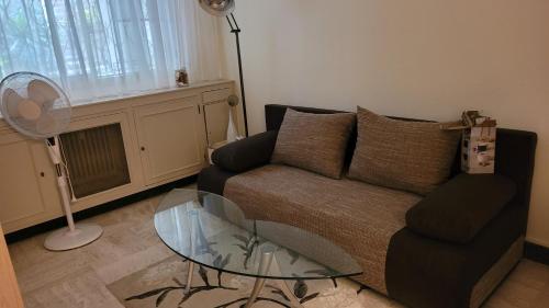 un salon avec un canapé et une table en verre dans l'établissement Studio, à Cannes
