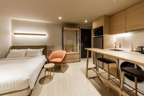 a hotel room with a bed and a kitchen at Nishitetsu Hotel Croom Bangkok Silom in Bangkok