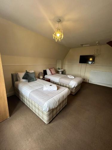 a bedroom with two beds and a chandelier at The Wheatley Hotel in Doncaster