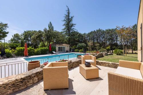 un patio avec des chaises et une piscine dans l'établissement SmartStay Mas Les Cedres - Proche Isle-sur-la-Sorgue, à Lagnes