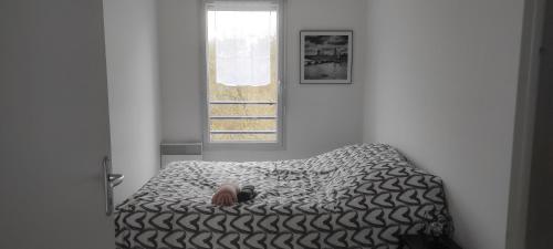 a person laying on a bed in a room at Capstay - Brest - Lambezellec- 7 minutes des plages et du port in Brest