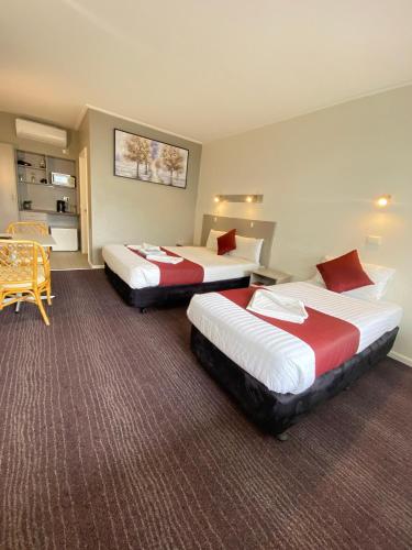 a hotel room with two beds and a table at Cobb Inlander Motel in Hay