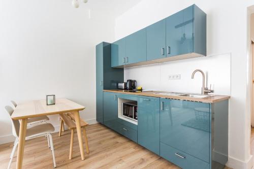 une cuisine avec des placards bleus et une table en bois dans l'établissement Charming apartment - 1BR-4P - Tour Eiffel, à Paris