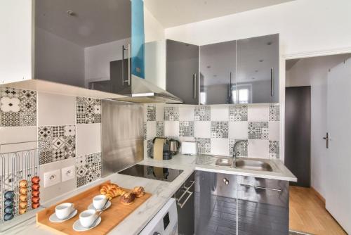 une cuisine avec un évier et un comptoir dans l'établissement GuestReady - Cosy Apartment in Le Marais, à Paris