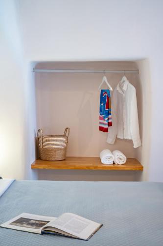 a bedroom with a shelf with a bed and a book at Okeanos Suite 1, Panoramic sea &garden view in Foinikiá