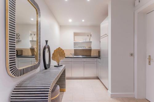 une salle de bain avec un miroir et un banc avec un lavabo dans l'établissement Cosy apartment ac balcony - 1BR-4P - Eiffel Tower, à Paris