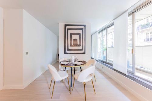 une salle à manger avec une table et des chaises blanches dans l'établissement Cosy apartment ac balcony - 1BR-4P - Eiffel Tower, à Paris