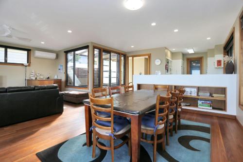 a kitchen and living room with a table and chairs at Expansive Myall River Views in Hawks Nest