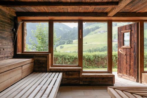 a room with a bench and a large window at Hotel Pichlmayrgut in Schladming