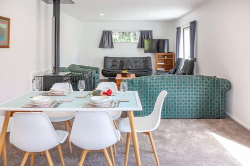 a living room with a table and chairs and a couch at Hanmer Four Seasons in Hanmer Springs