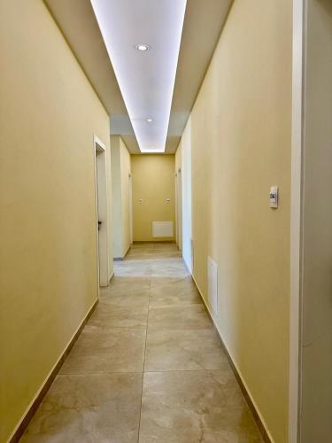 an empty hallway with yellow walls and a ceiling at Zeus Hotel in Shëngjin