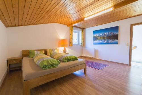ブルック・アン・デア・グロースグロックナーシュトラーセにあるChalet Drei Brüderのベッドルーム1室(緑の枕が付いたベッド1台付)