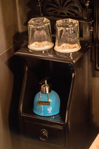 a wooden table with two glasses and a blue item at The Temi Bungalow South Sikkim in Namchi